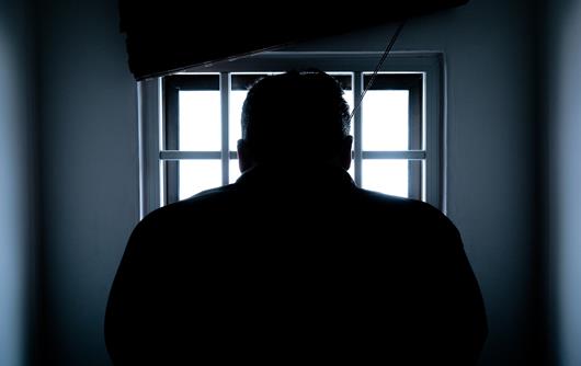 man in a dark prison cell