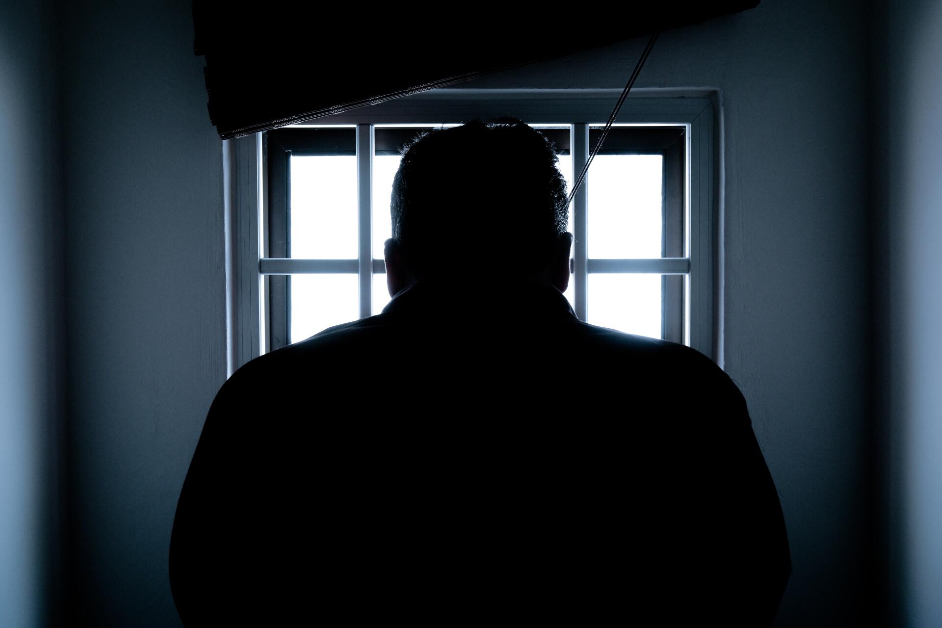 man in a dark jail cell