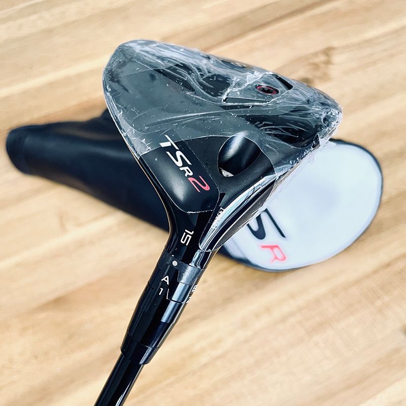 Titleist TSR2 driver with plastic wrap, black headcover, and wooden surface.