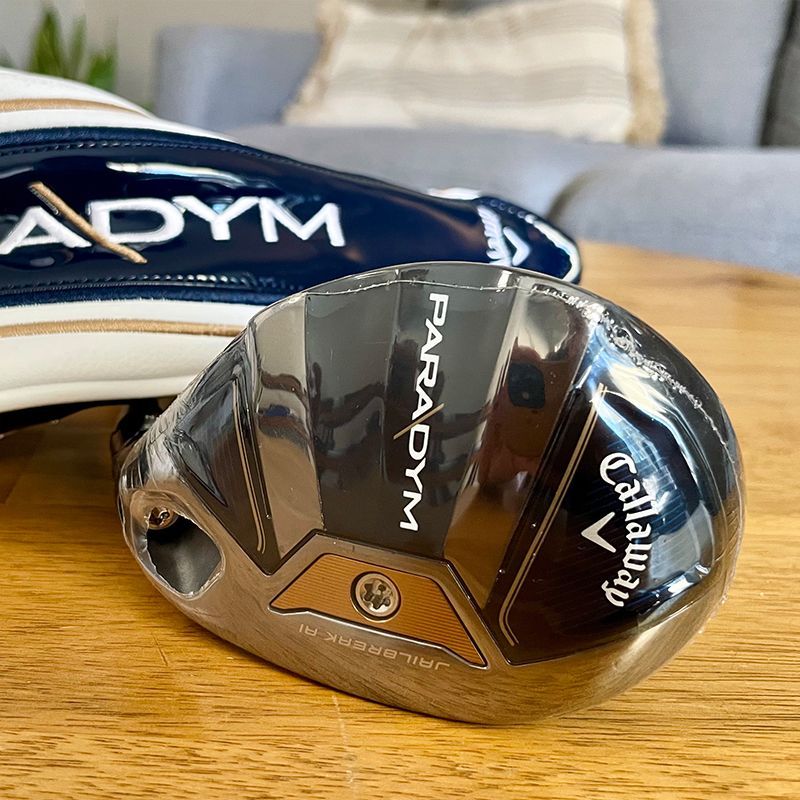 Callaway Paradym golf club head with its head cover on a wooden surface.