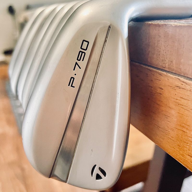 Close-up of a TaylorMade P.790 golf club. The club head is silver with the model name printed on it.