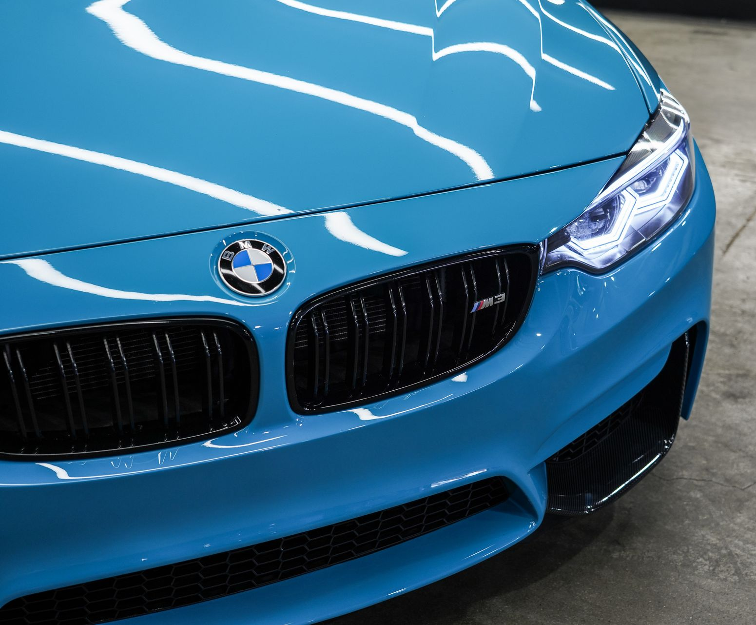 Blue BMW front grille and headlights in a showroom-like setting