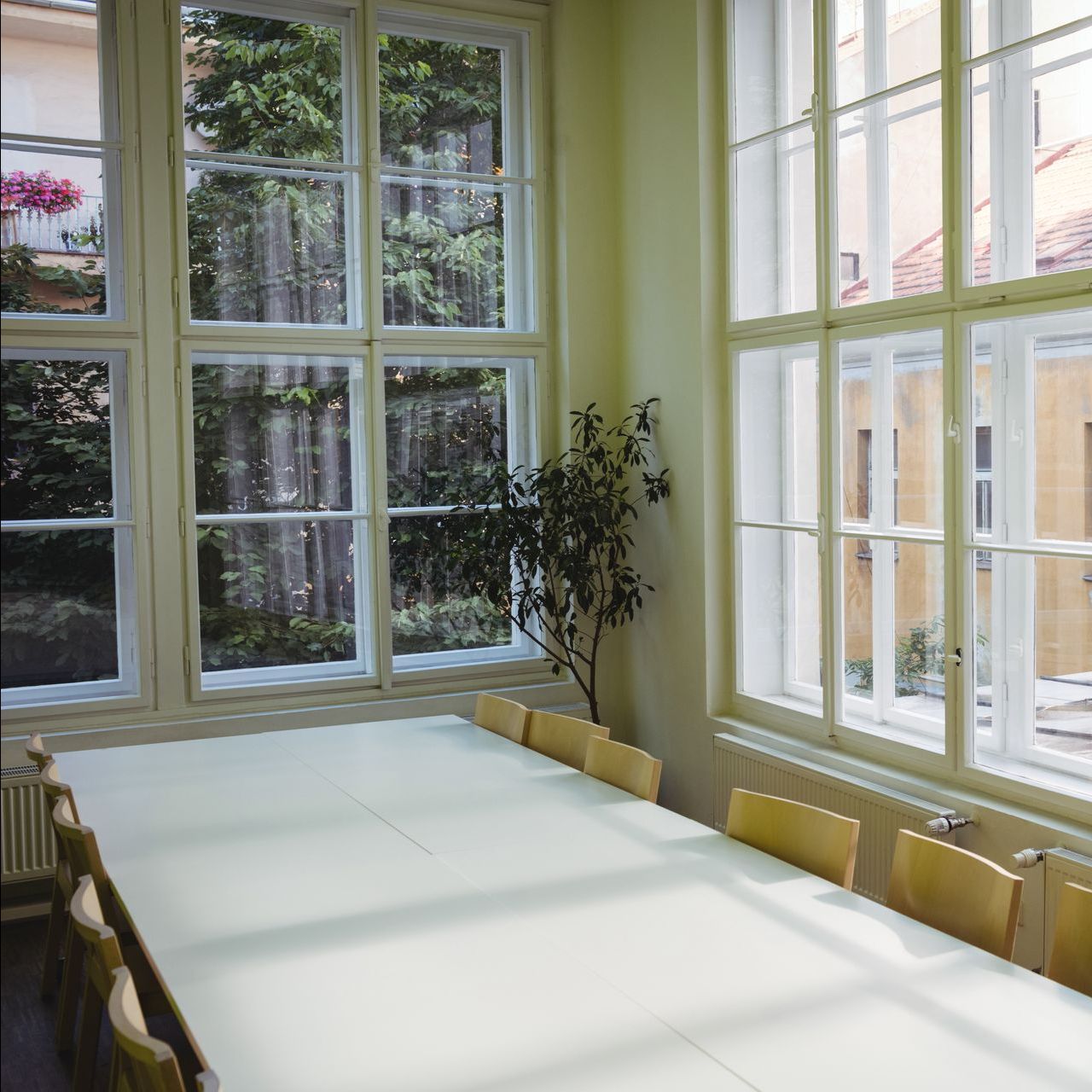 A room with a table and chairs and lots of windows