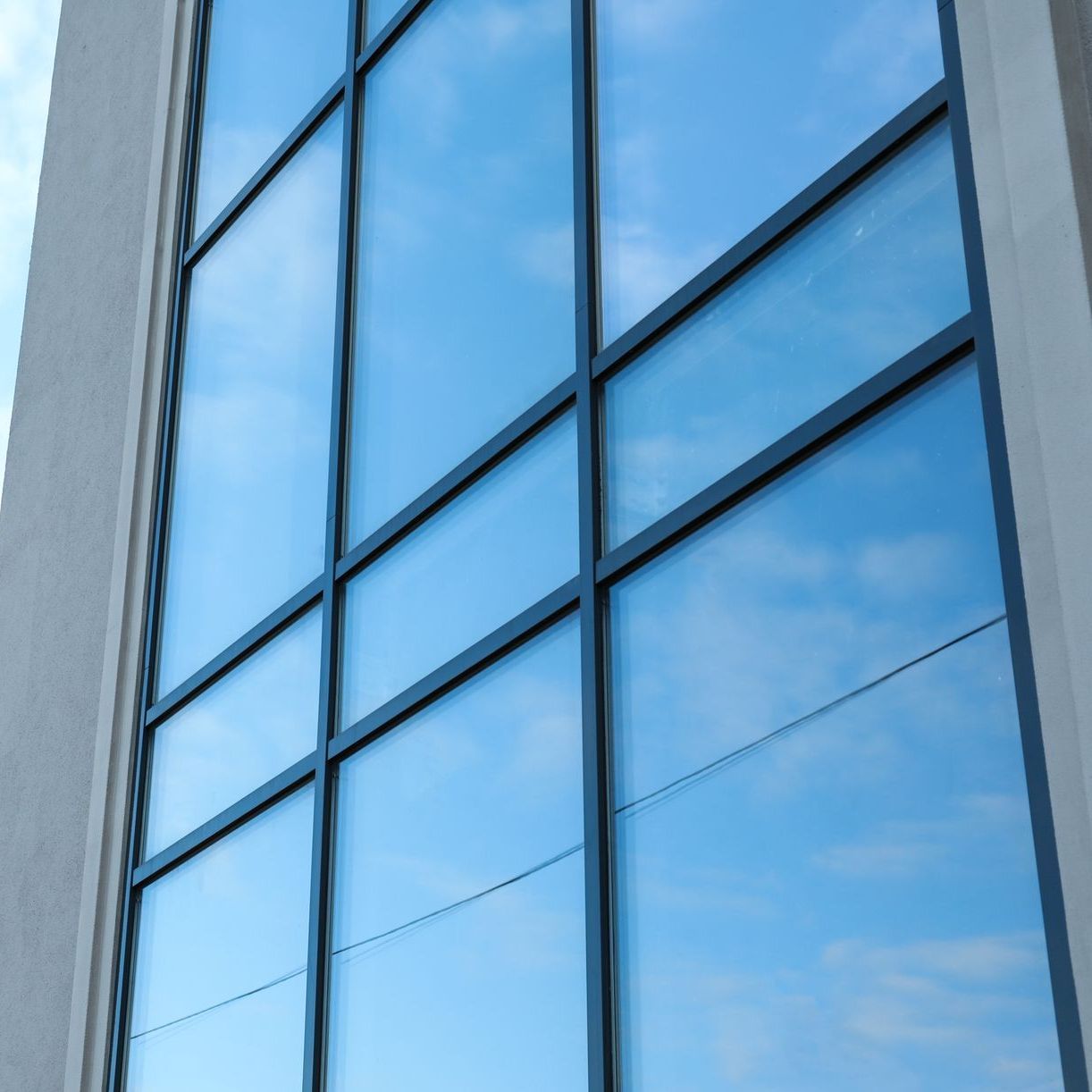 A building with a blue sky reflected in the windows