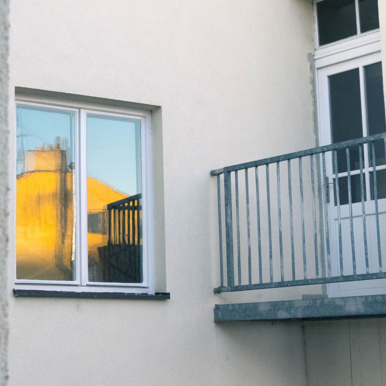 A white building with a balcony and a window
