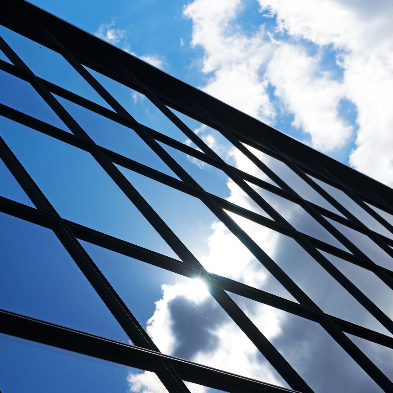 Looking through a fence at the sky with clouds