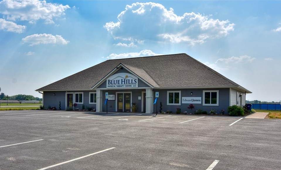 Blue Hills Veterinary Clinic, a light blue building, on a sunny day.