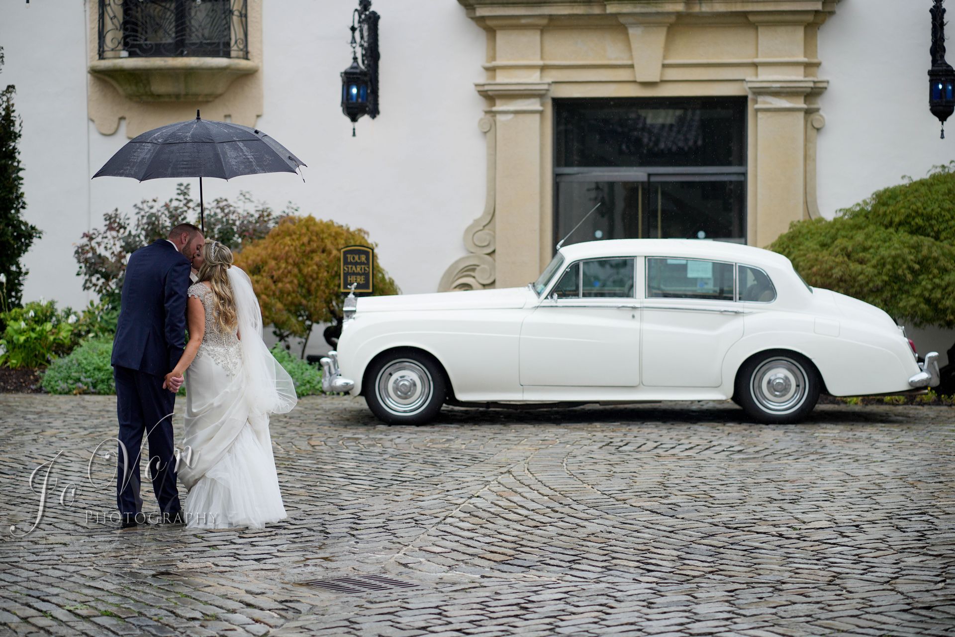 A bride and her bridesmaids are sitting on a limousine.