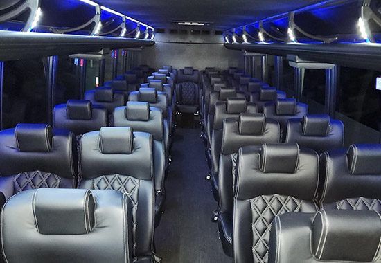 The inside of a bus with a lot of seats and blue lights.