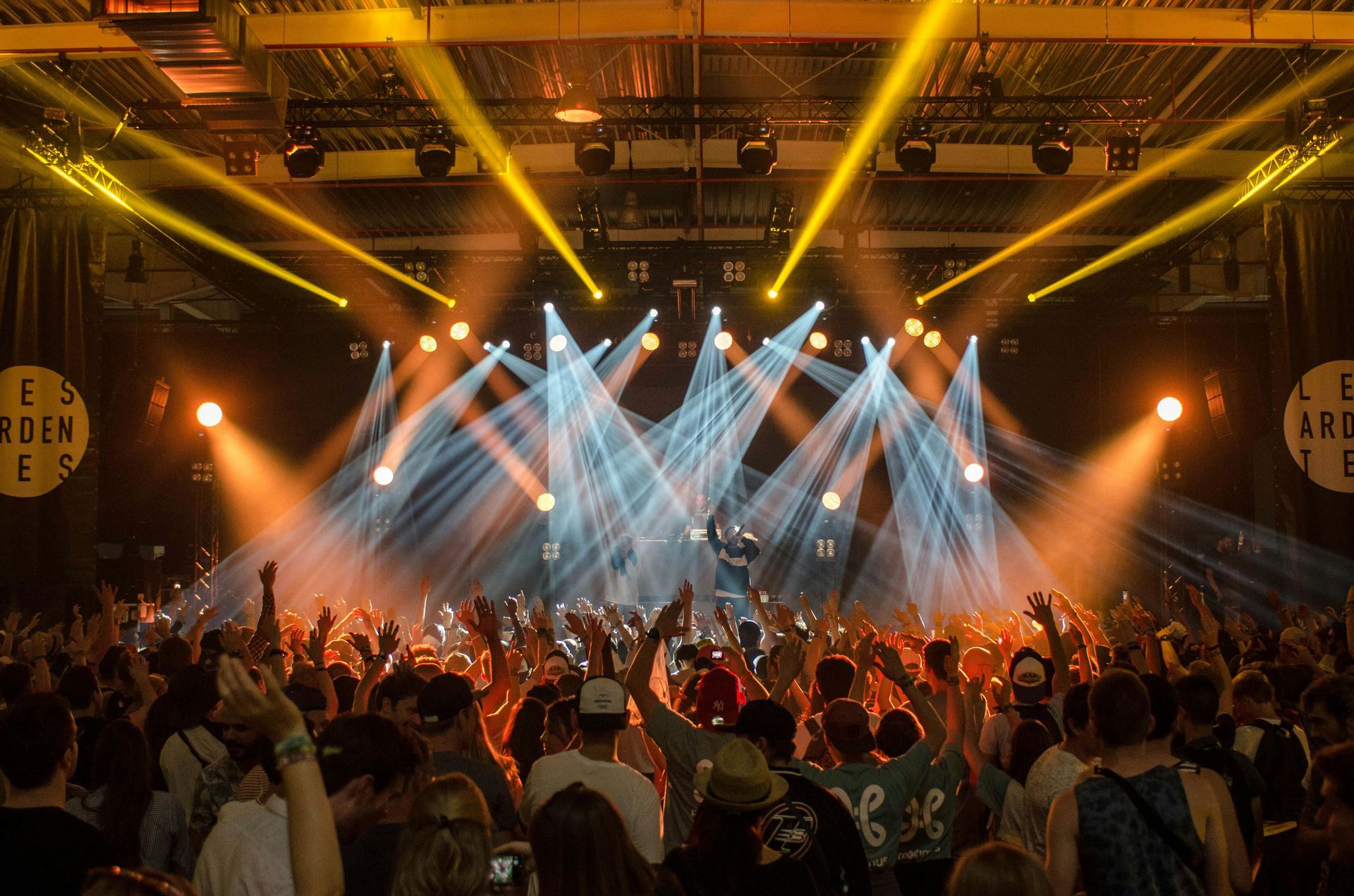 A crowd of people are standing in front of a stage at a concert.