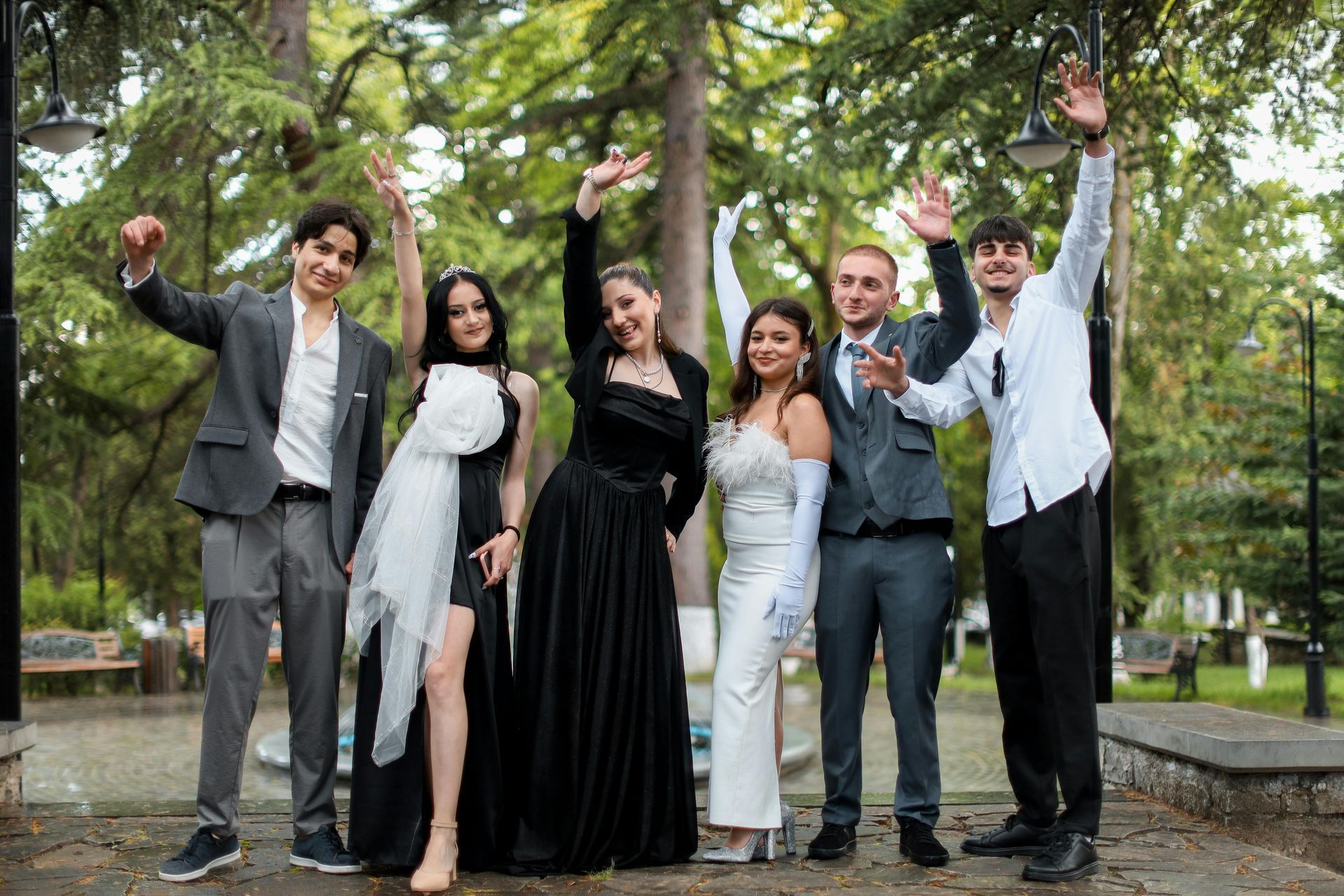 A group of young people are posing for a picture in a park.