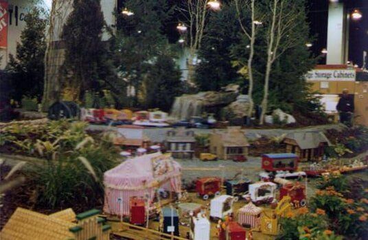 Miniature town and forest diorama with waterfall, trees, and buildings.