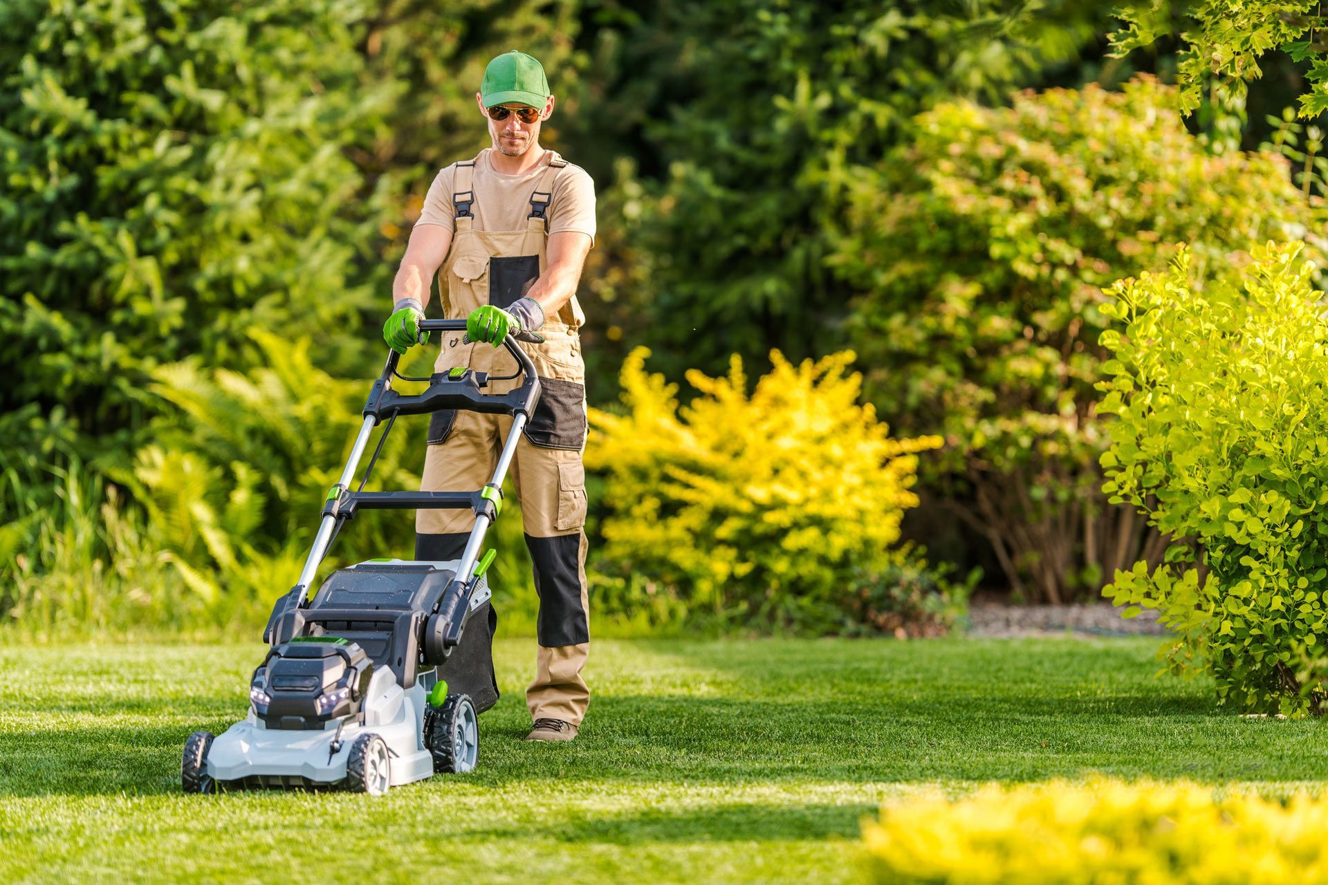 A man mowing a lush yard, demonstrating expert care and quality landscaping services.