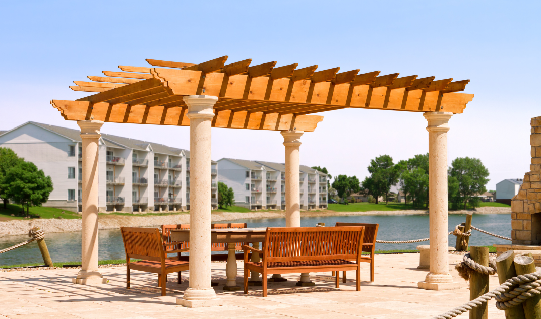 wooden pergola by lake with table