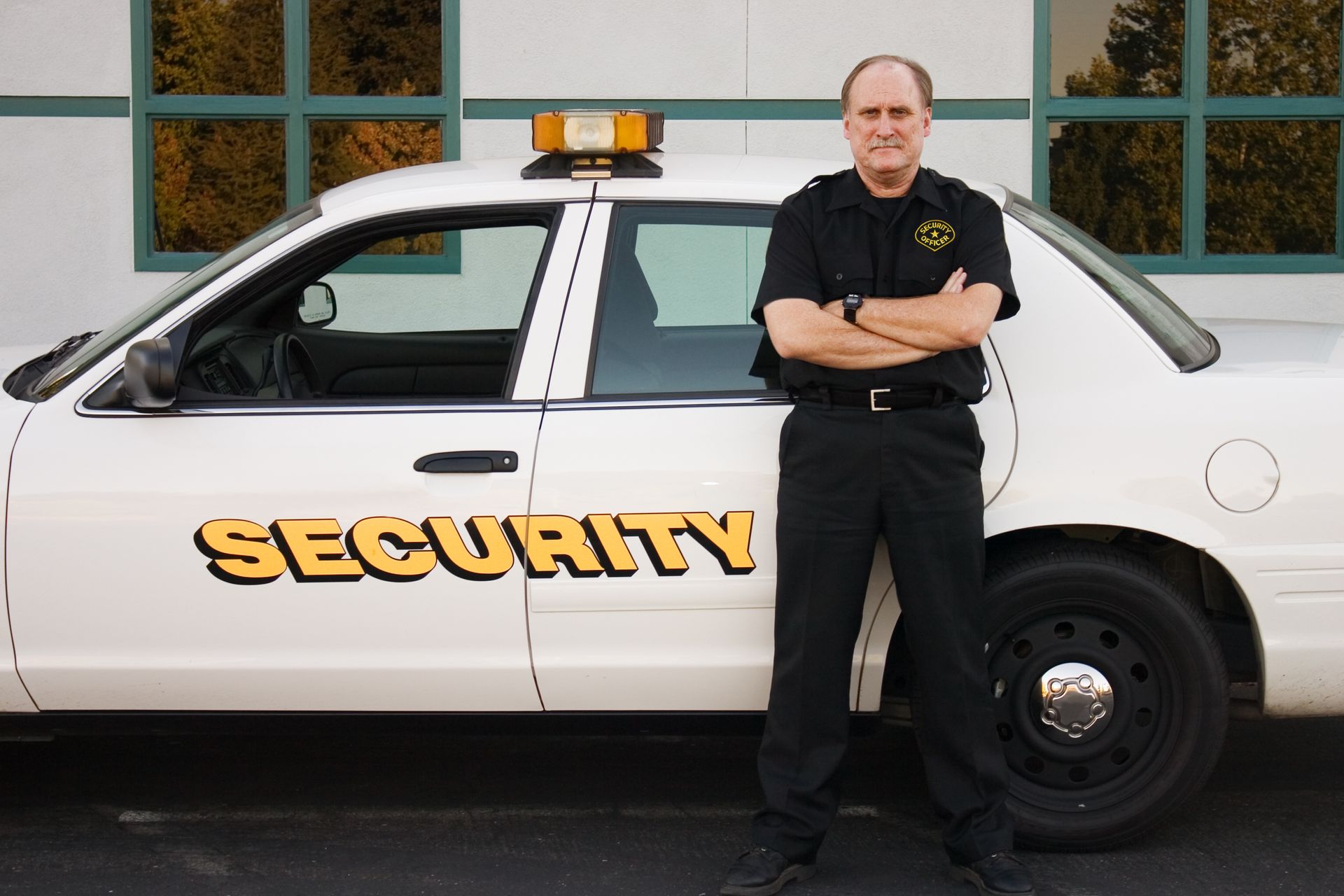 A man standing next to a white security car