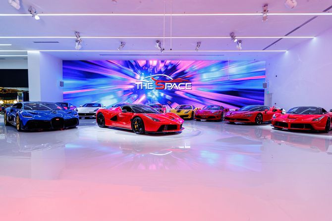a row of red sports cars are parked in a showroom .