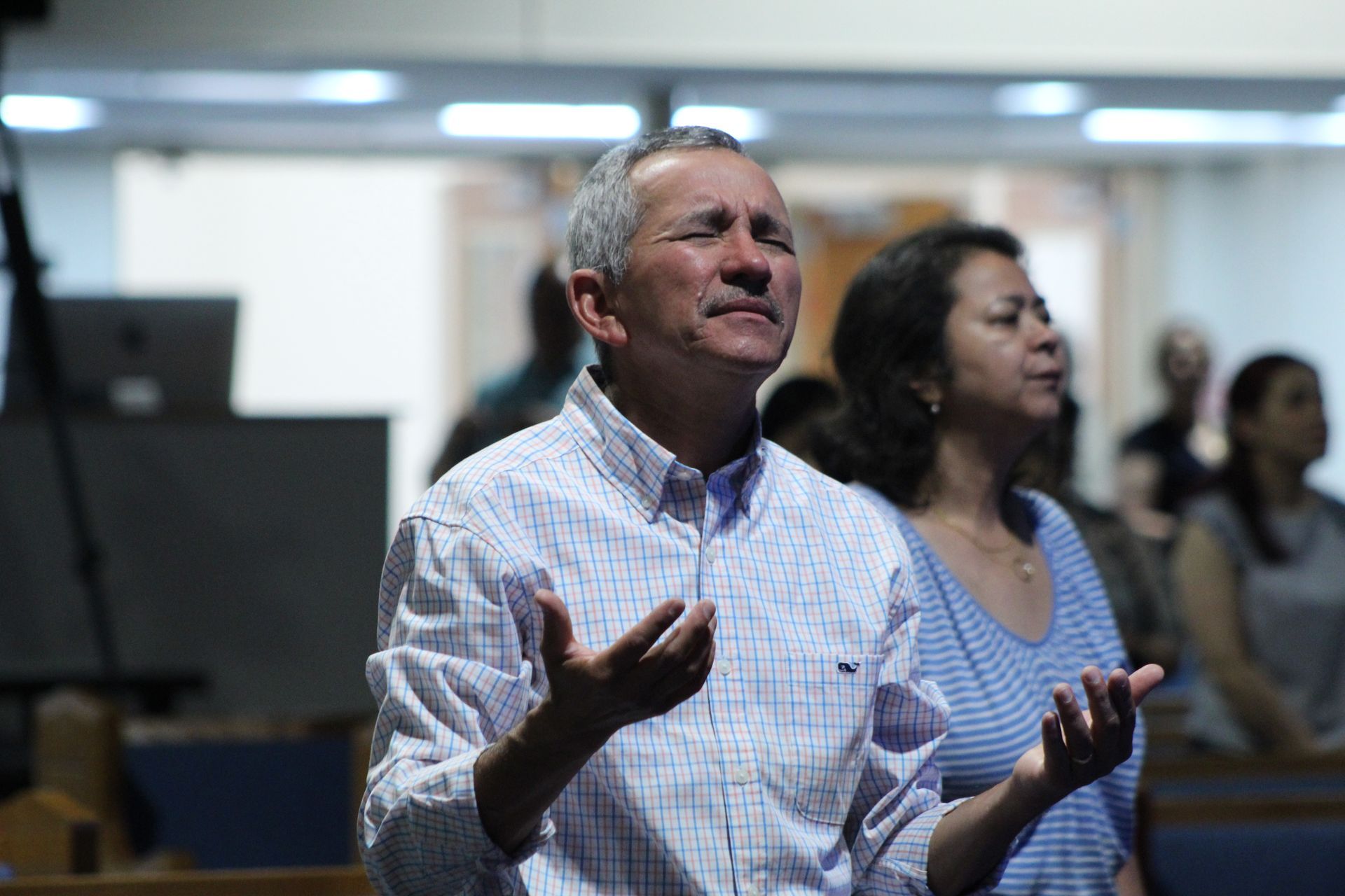 Un hombre y una mujer están orando en una iglesia.