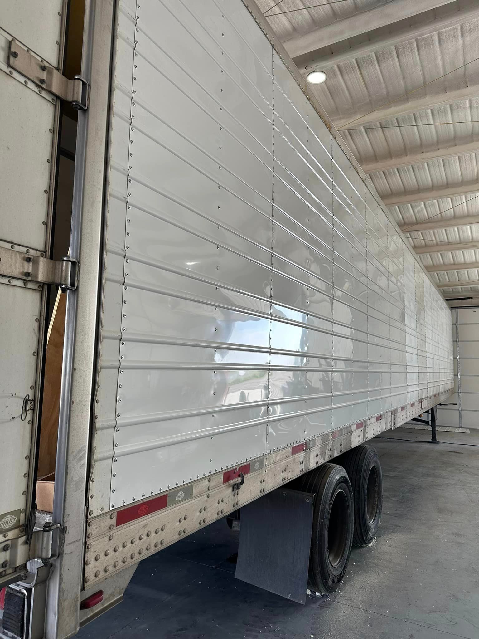 A white semi truck is parked in a garage.