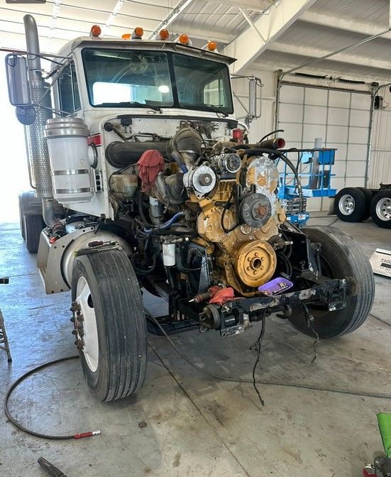 A truck with its engine removed is sitting in a garage.