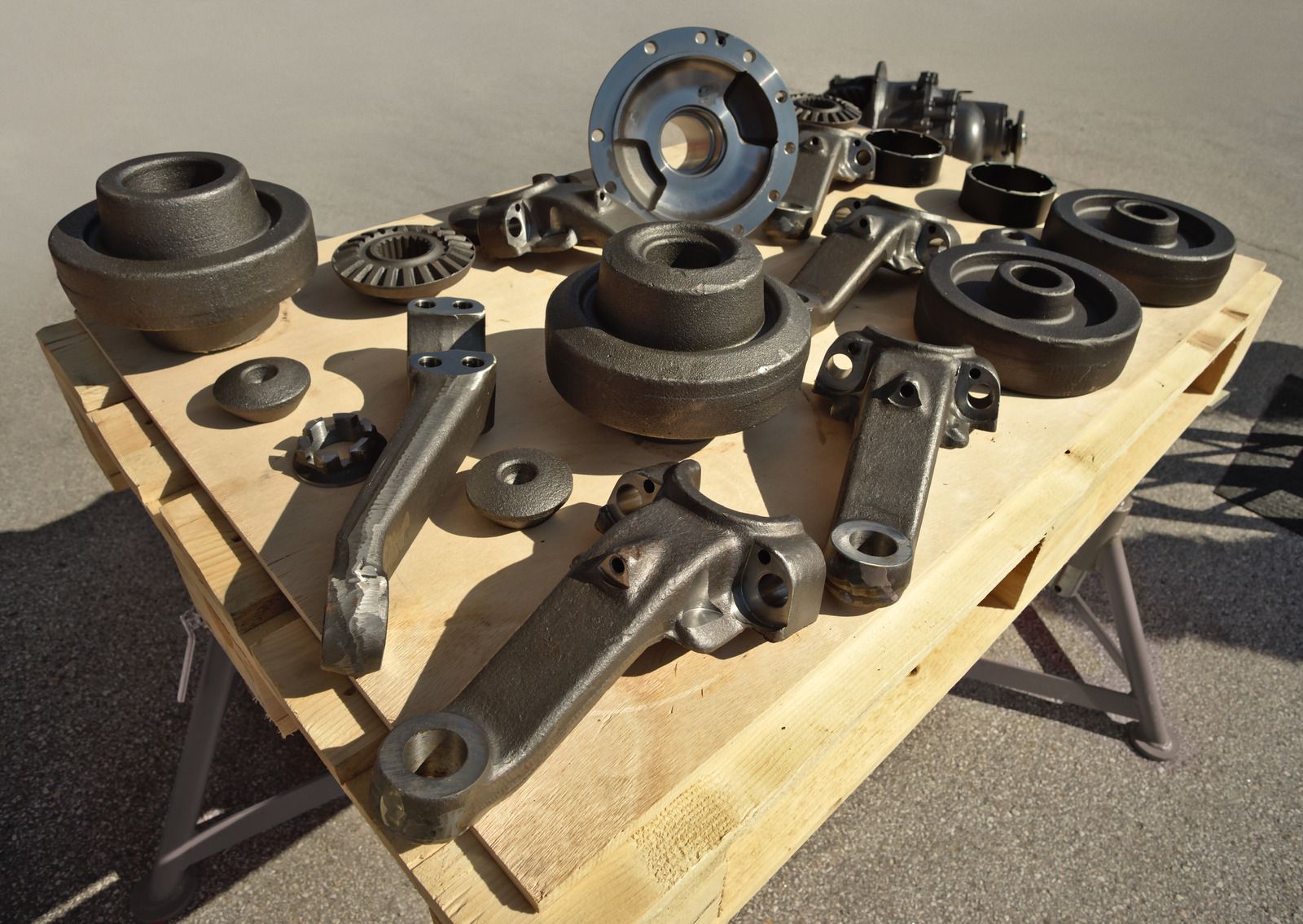 A wooden table with a bunch of metal parts on it