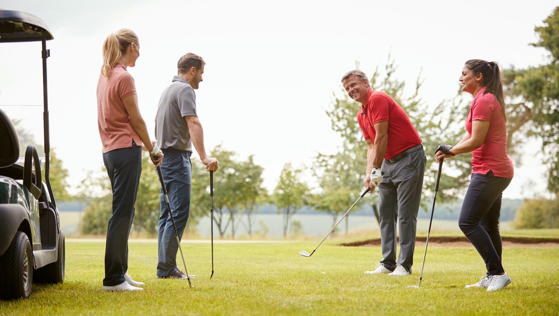 A group of people are playing golf on a golf course.