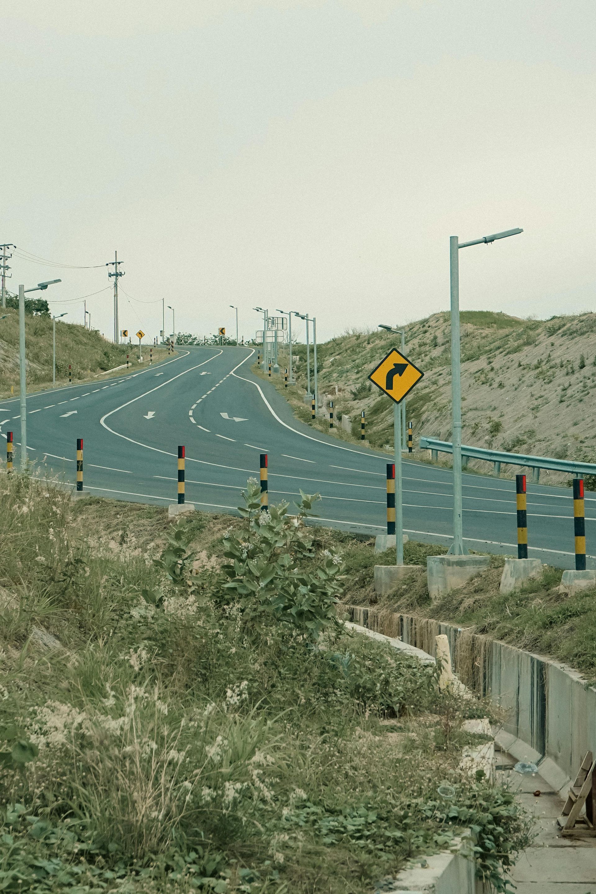 A road with a yellow sign on the side of it