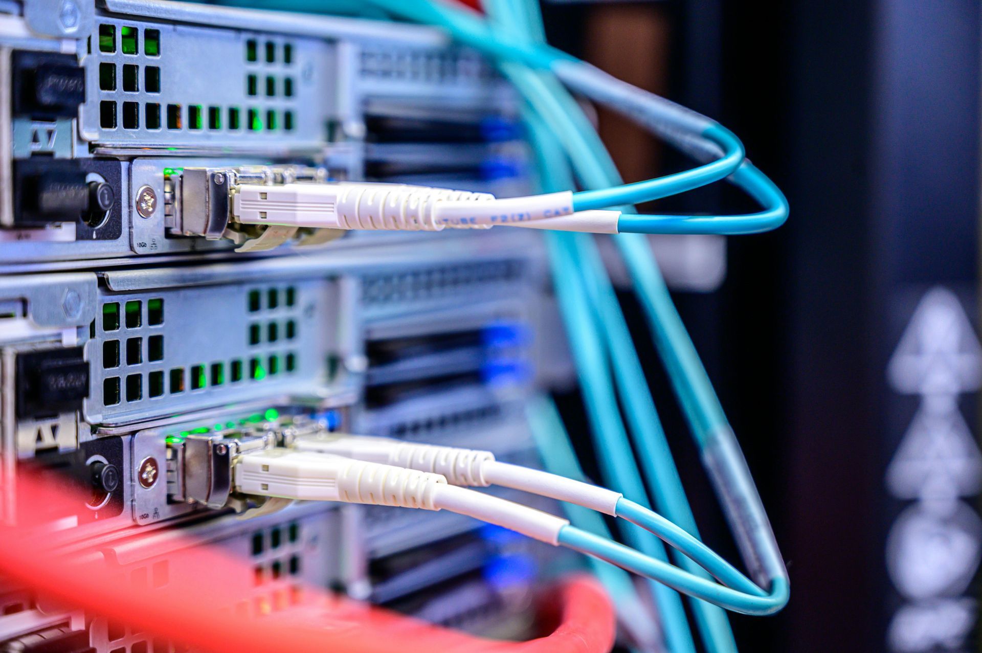 Server racks with connected fiber optic cables, showing data center infrastructure.