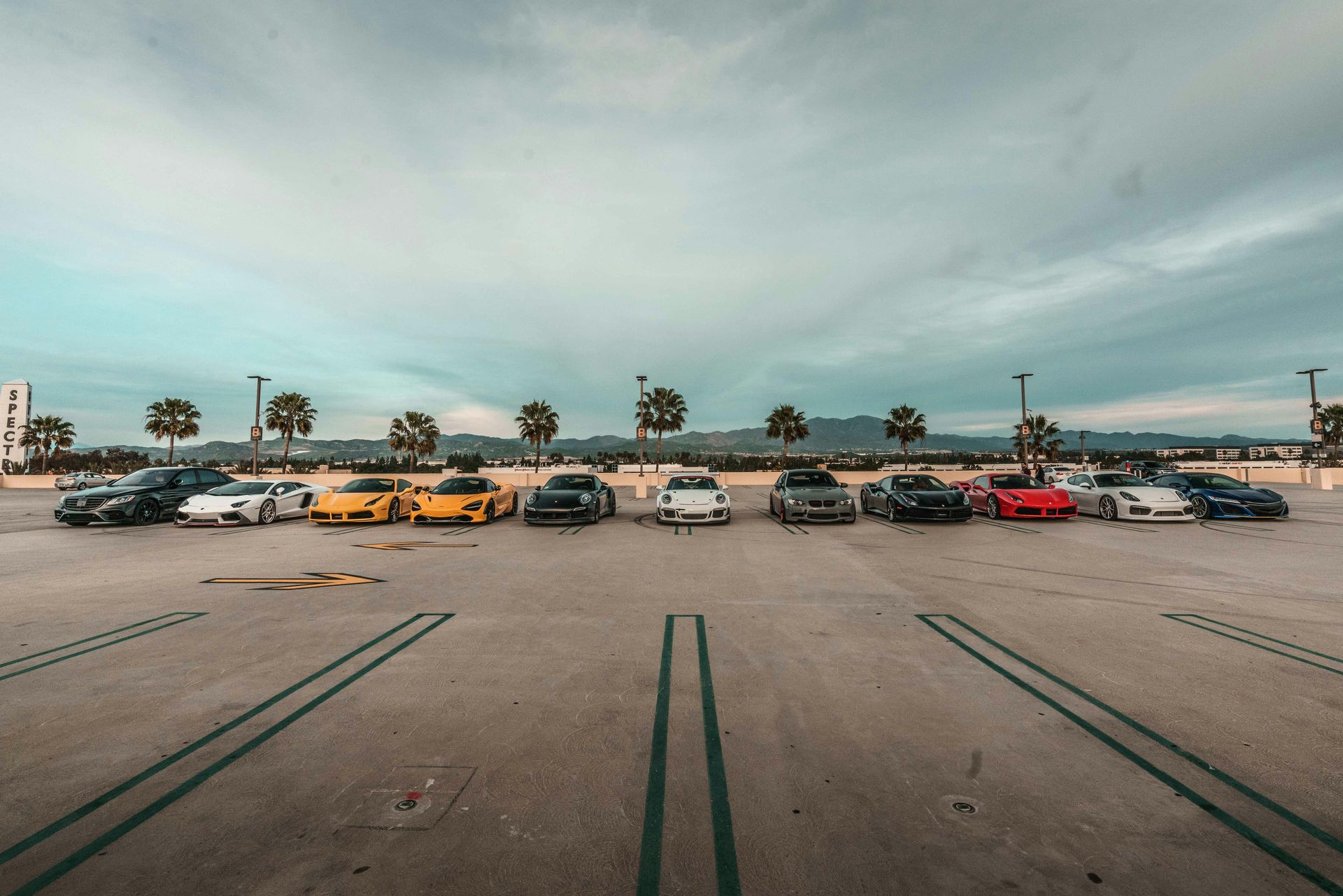 A row of cars are parked in a parking lot.