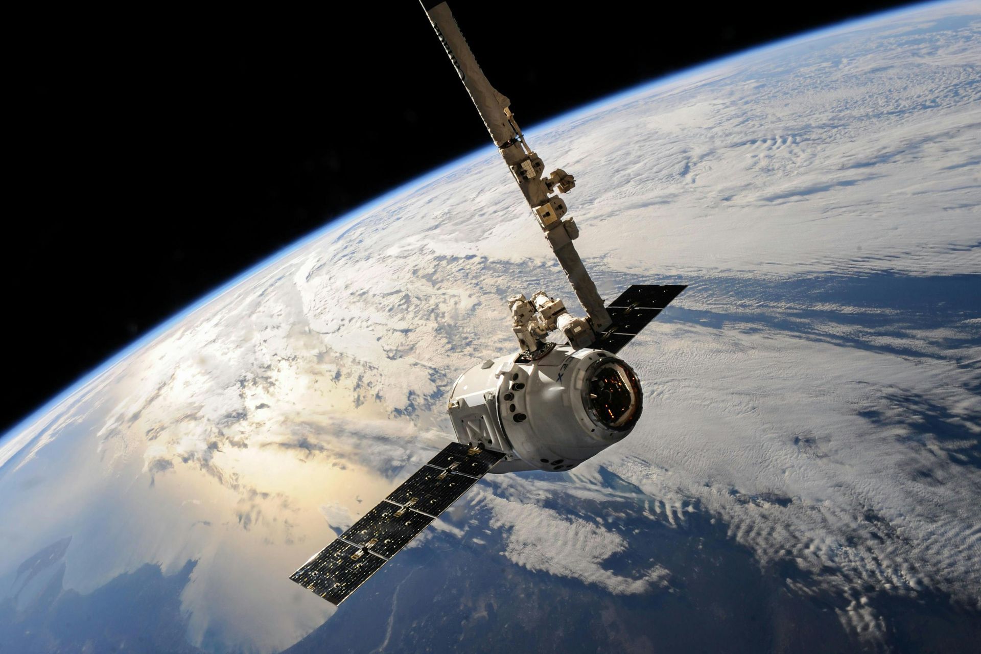 SpaceX Dragon spacecraft docked to the International Space Station, against the backdrop of Earth.