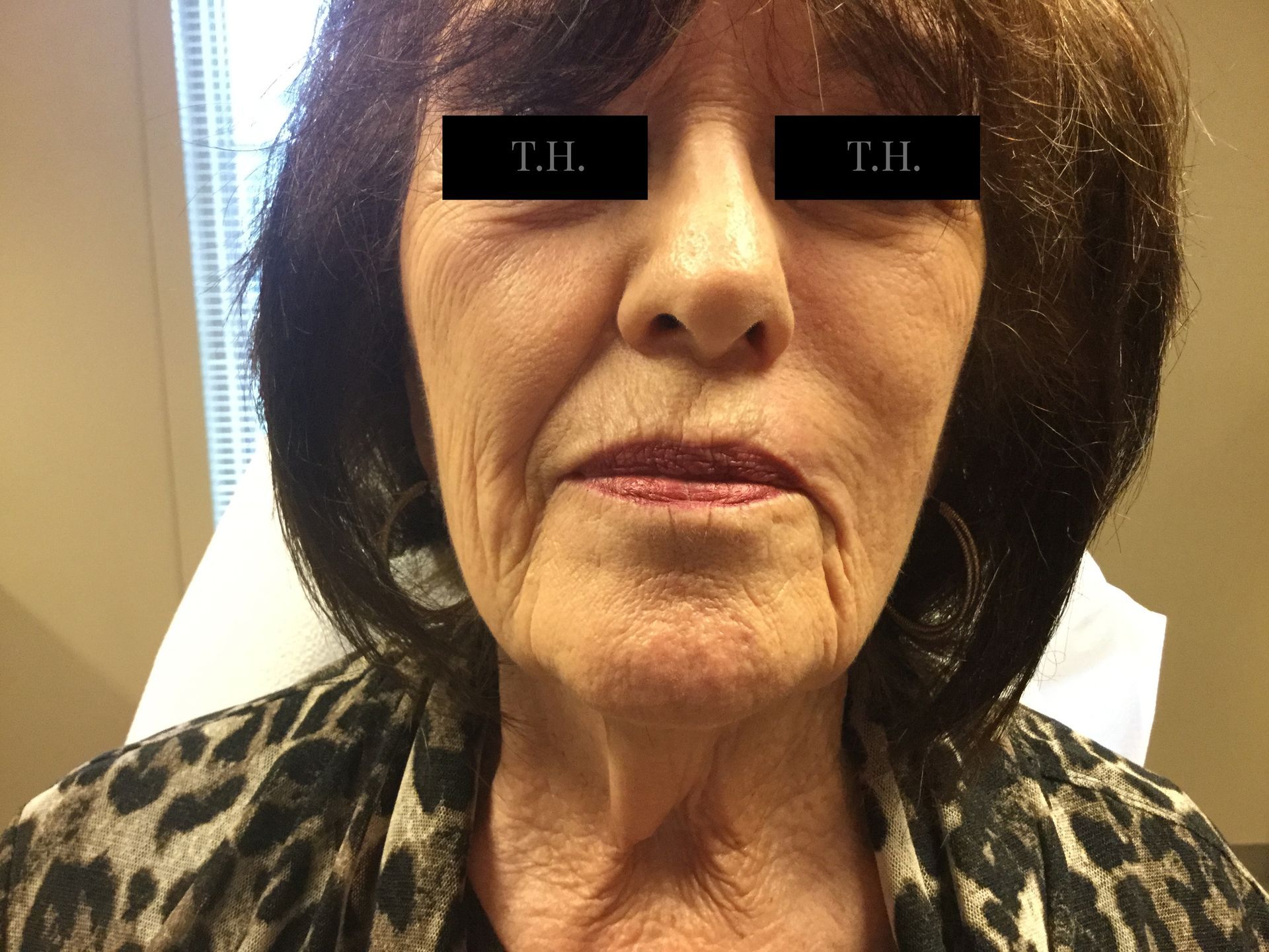 A close up of a woman 's face with a leopard print shirt.