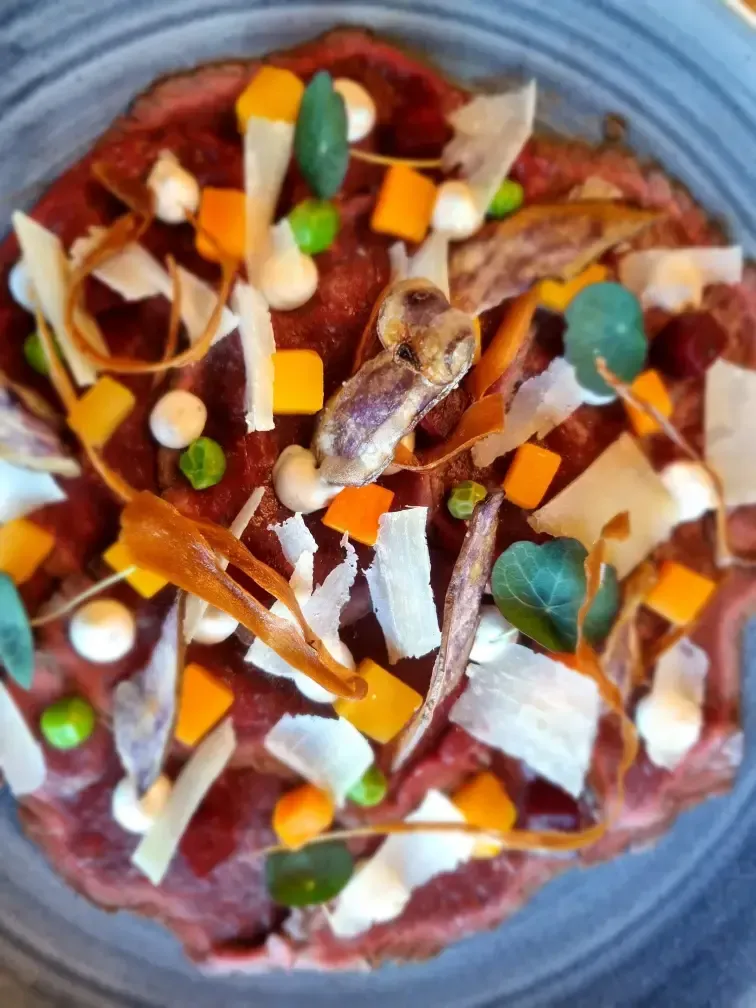 een bord eten met vlees en groenten erop