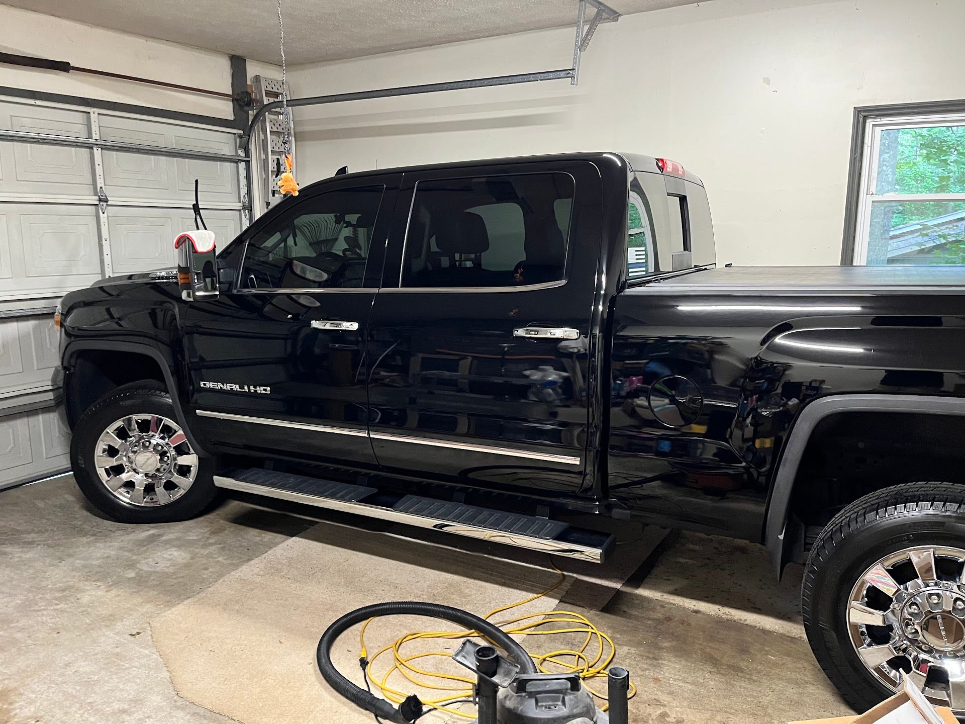 Black pickup truck parked inside a garage.