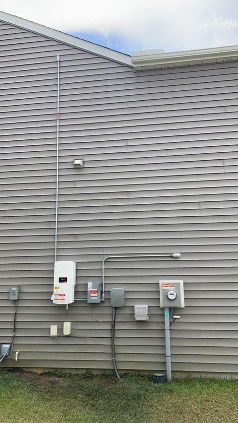 A house with a lot of electrical outlets on the side of it.