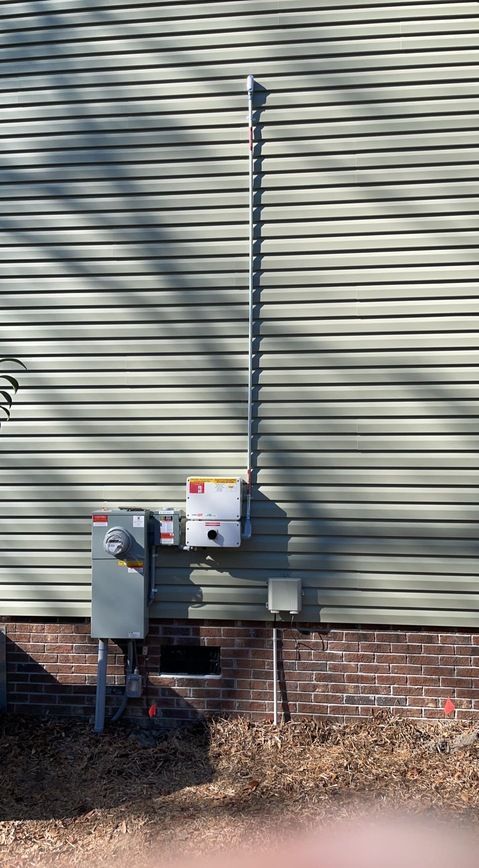 A house with a electrical box on the side of it.