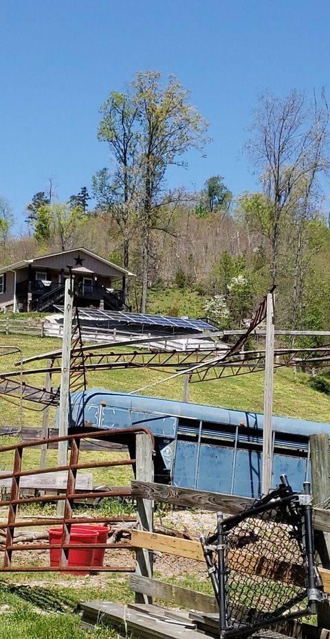 A fenced in area with a pool and a house in the background.