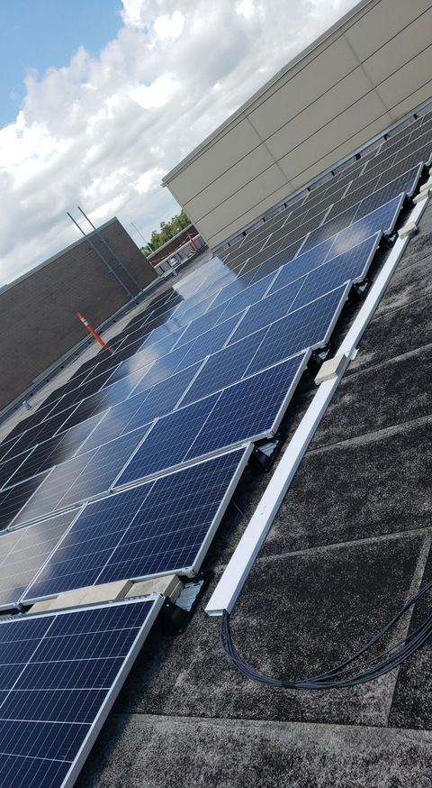 A row of solar panels on the roof of a building.