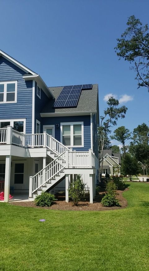 A blue house with solar panels on the roof