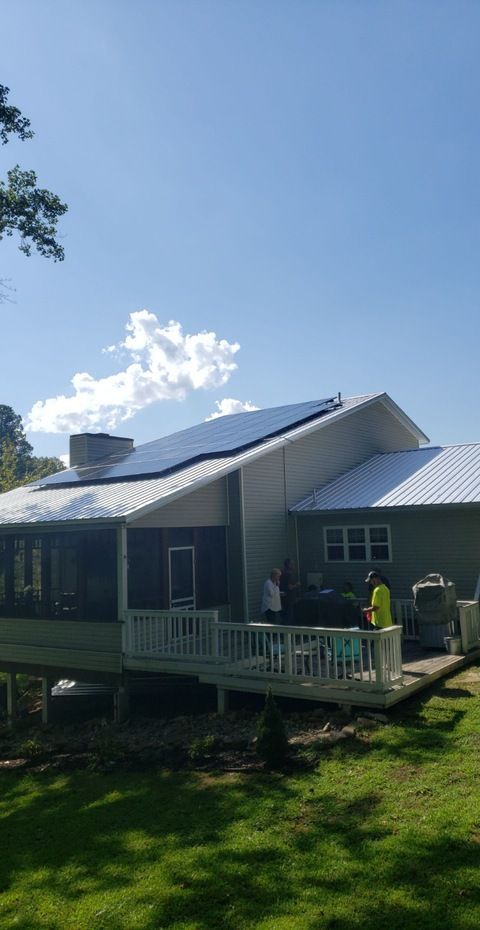 A house with a screened in porch and solar panels on the roof.
