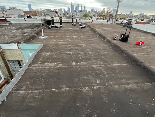 A rooftop with a view of the city skyline and a suitcase on it.