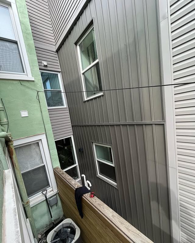 A view of a building from a balcony with a washer and dryer.