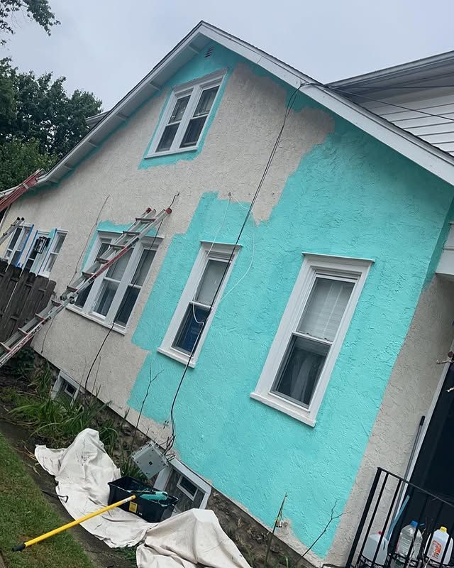 The side of a house is being painted blue.
