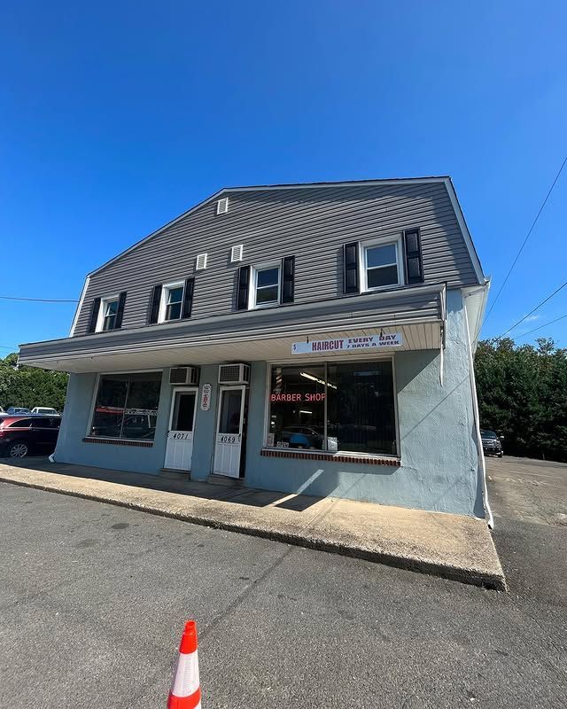 A large building with a lot of windows is sitting on the side of the road.