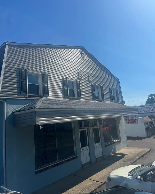 A building with a car parked in front of it on a sunny day.