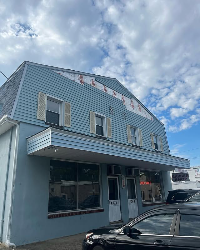 A blue building with a car parked in front of it.