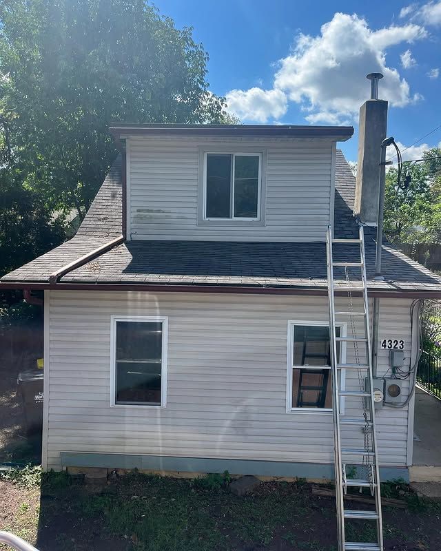 A white house with a ladder on the side of it.