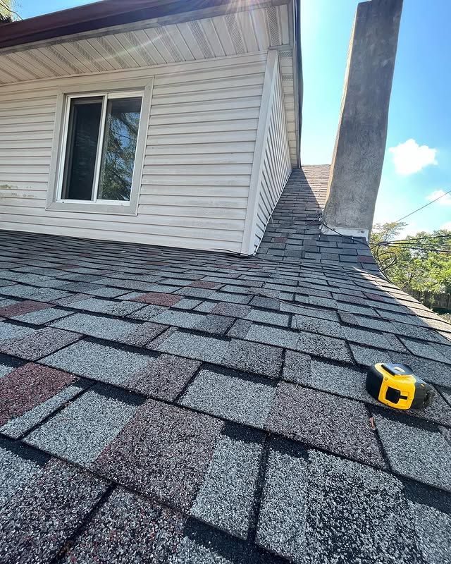 A tape measure is laying on the roof of a house.