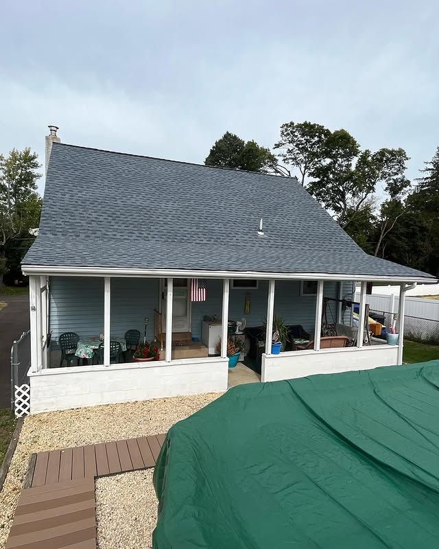 A small house with a blue roof and a large porch.