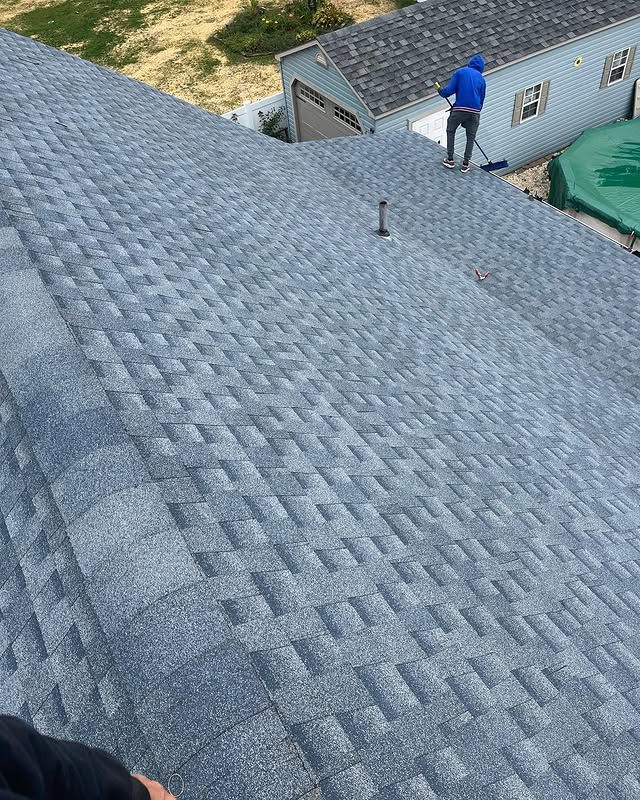 A man is standing on the roof of a house.
