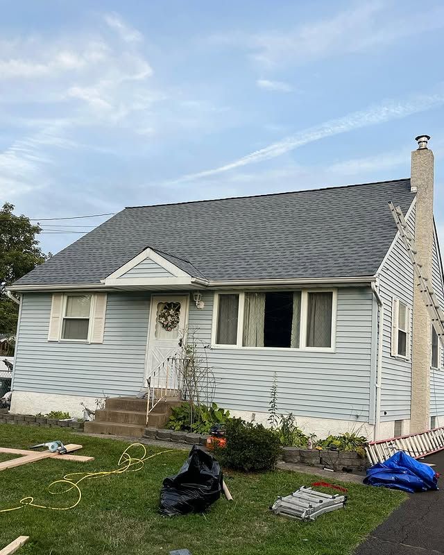 A blue house with a gray roof is being remodeled.