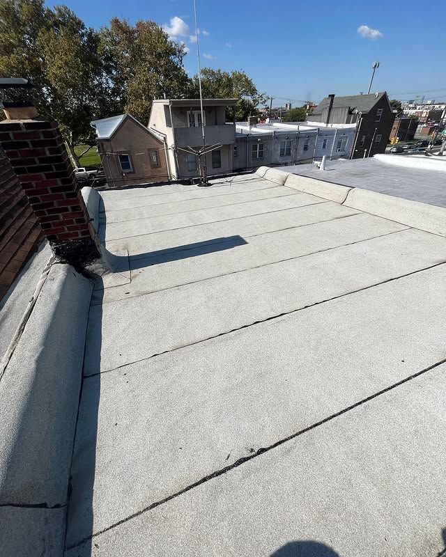 The roof of a building with a flat roof and a chimney.
